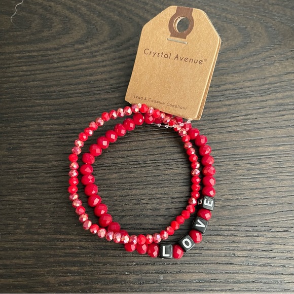 Jewelry - TWO RED BEADED CRYSTAL STRETCH LOVE BRACELETS WITH BLACK AND WHITE LETTERING.